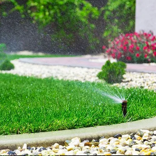 Close-up of Lushline Garden Landscaping and Irrigation expert repairing an underground water irrigation system.